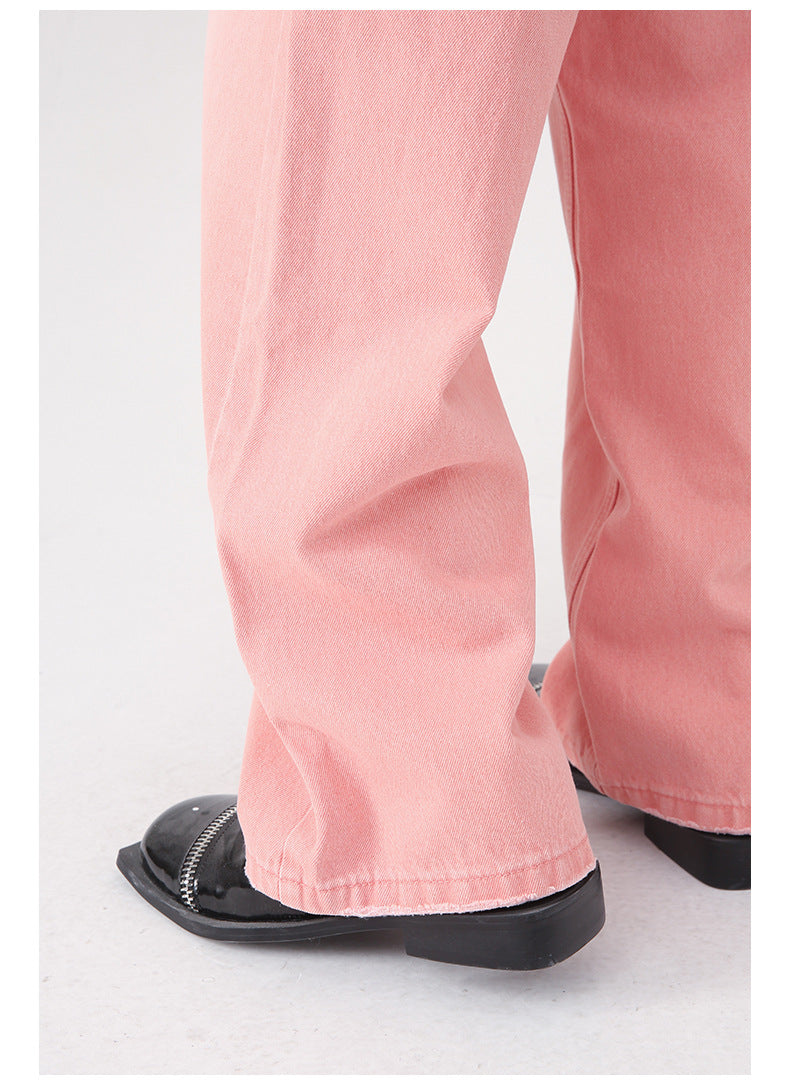 Close-up of pink denim wide-leg pant hem and cuff detail with black patent leather shoe visible