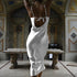 Back view of white silk evening gown with tie detail, photographed in ornate interior with classical details
