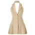 A beige halterneck blazer mini dress with lapel collar, button-front closure and pleated skirt, displayed on white background