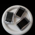 Three clear plastic boxes containing black bobby pins arranged on white ceramic plate, professional hair styling supplies