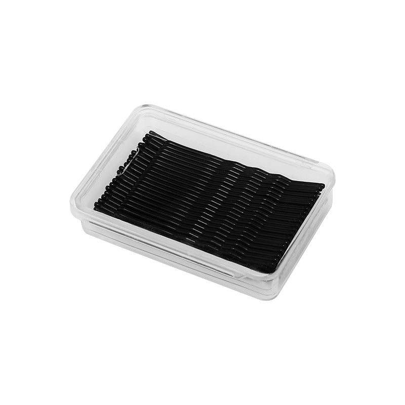 Clear plastic storage box filled with organized black bobby pins, professional hair styling supplies