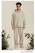 Man with twisted hair wearing beige hoodie and sweatpants with white sunglasses and silver chain