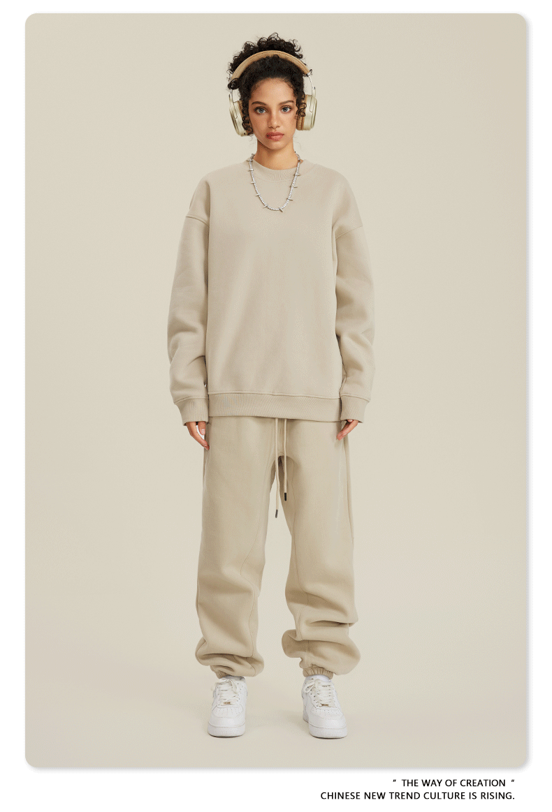 Model in cream sweatsuit with beige headphones, silver jewelry and white Air Force 1 sneakers
