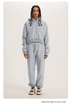 Heather Grey Sweatshirt and Joggers Set – Model wears a light grey cropped hoodie and joggers with casual sneakers