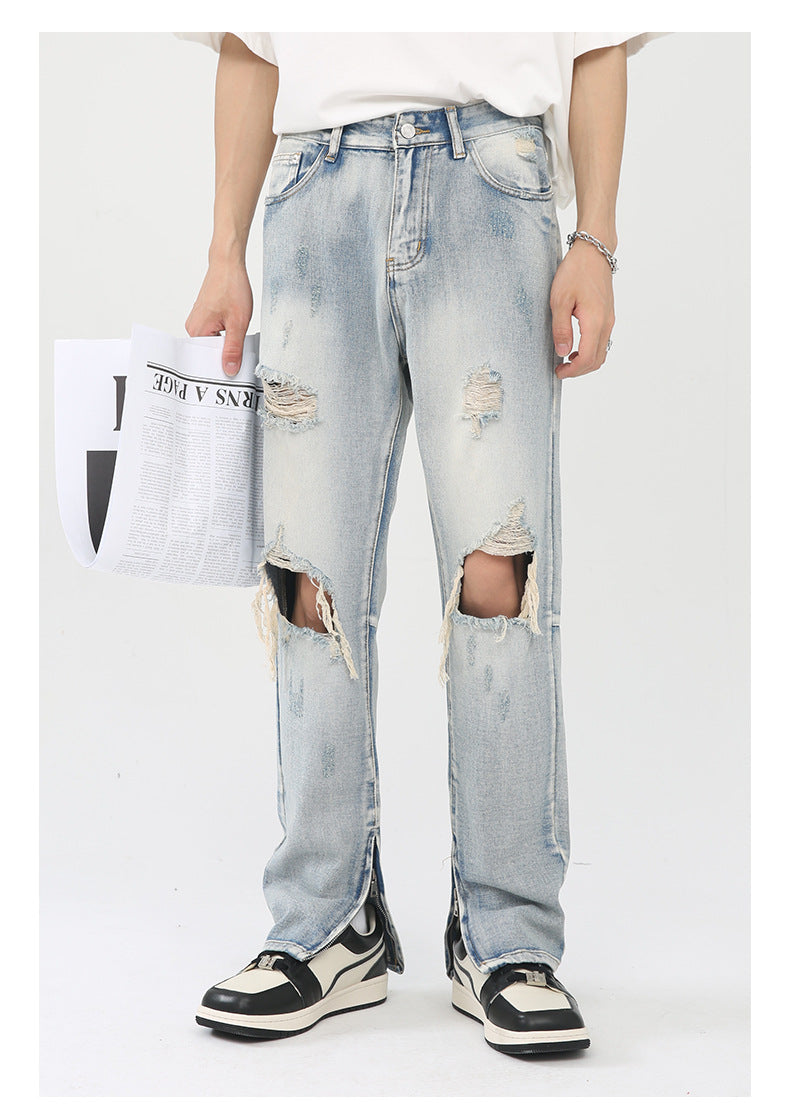 Front view of ripped light wash jeans styled with oversized white tee, silver accessories and retro sneakers against white