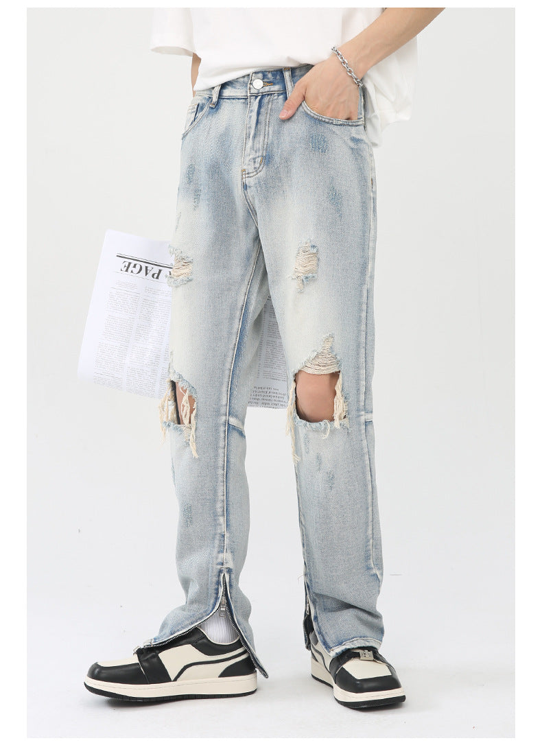 Side profile of distressed light wash denim with knee tears and ankle zips, paired with white t-shirt on white background