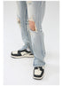 Close-up of ankle zip detail and bottom hem of light wash jeans over black and white retro sneakers