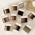 Multiple boxes of Henju hair bands in various neutral colors displayed on white surface, each labeled "Strong Elasticity"