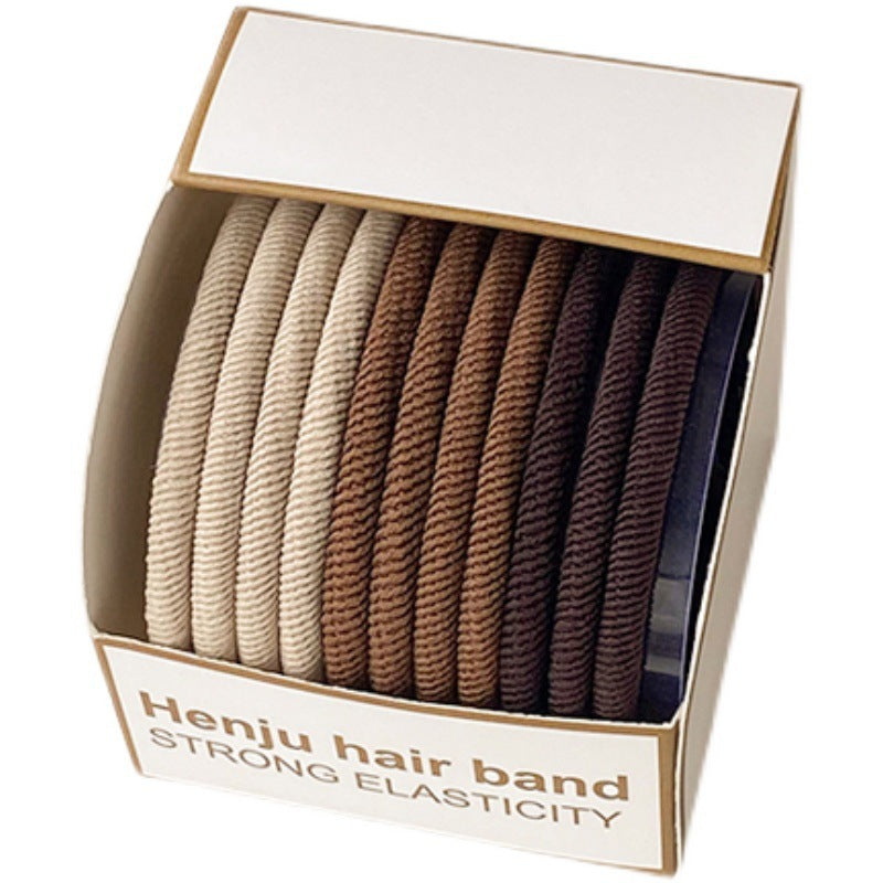 Open box of Henju hair bands showing color gradient from beige to brown to black, arranged in neat rows, labeled "Strong Elasticity"