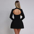 A model wearing a black mini dress with open back design stands against a gray background, showing the dress's circular cutout