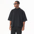 Side profile of model in black sunglasses wearing oversized black mock neck t-shirt and black cargo pants against white background