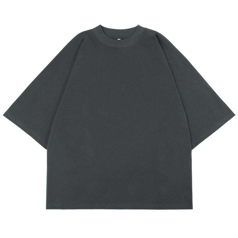 Flat lay product shot of charcoal gray oversized mock neck t-shirt with wide sleeves against white background