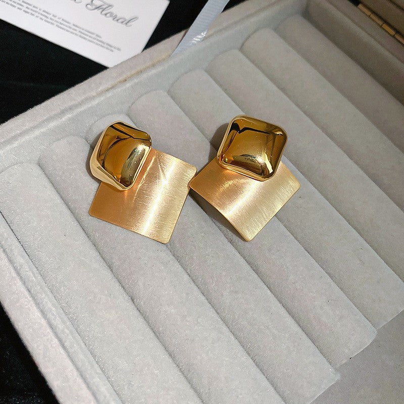 Gold Geometric Square Earrings – Stylish gold earrings featuring a mix of polished and brushed square elements, displayed in a jewelry box