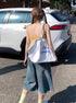 Back view, walking away shot – Loose fit denim shorts with back pockets and distressed hem.