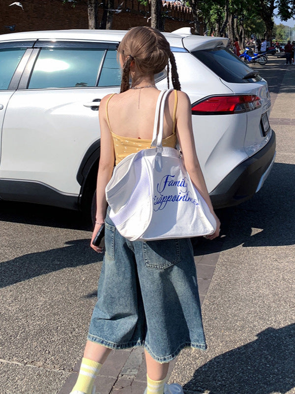 Back view, walking away shot – Loose fit denim shorts with back pockets and distressed hem.
