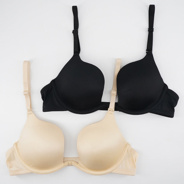 Two push-up bras in black and nude colors with molded cups and adjustable straps, flat lay product photography on white background