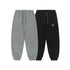 A pair of gray and black jogger sweatpants with elastic cuffs, drawstring waistbands, and small embroidered logos