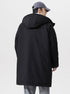 A man wearing gray cap shows back view of black NEIGHBORHOOD parka with hood detail against white background displaying coat construction