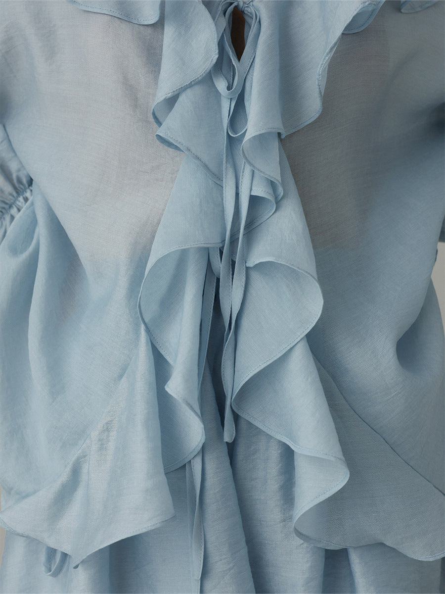 Light blue ruffled blouse on a plain background