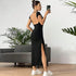 Another mirror selfie showing black maxi dress with open back design and side slit, paired with white sneakers