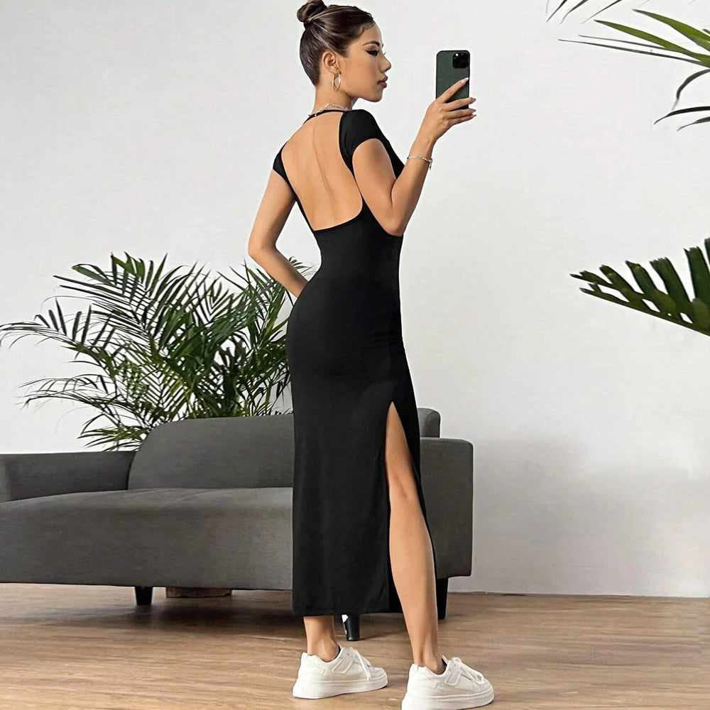 Another mirror selfie showing black maxi dress with open back design and side slit, paired with white sneakers