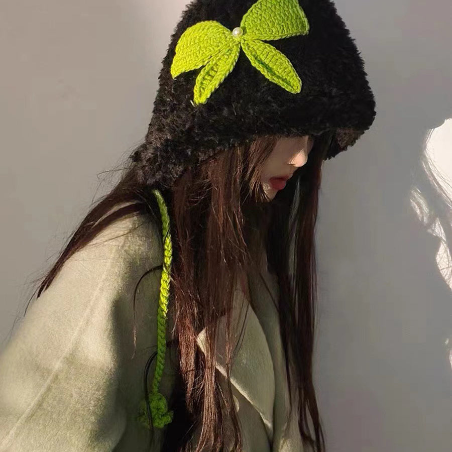 Black fuzzy winter hat adorned with neon green crochet bow and coordinating braided ties