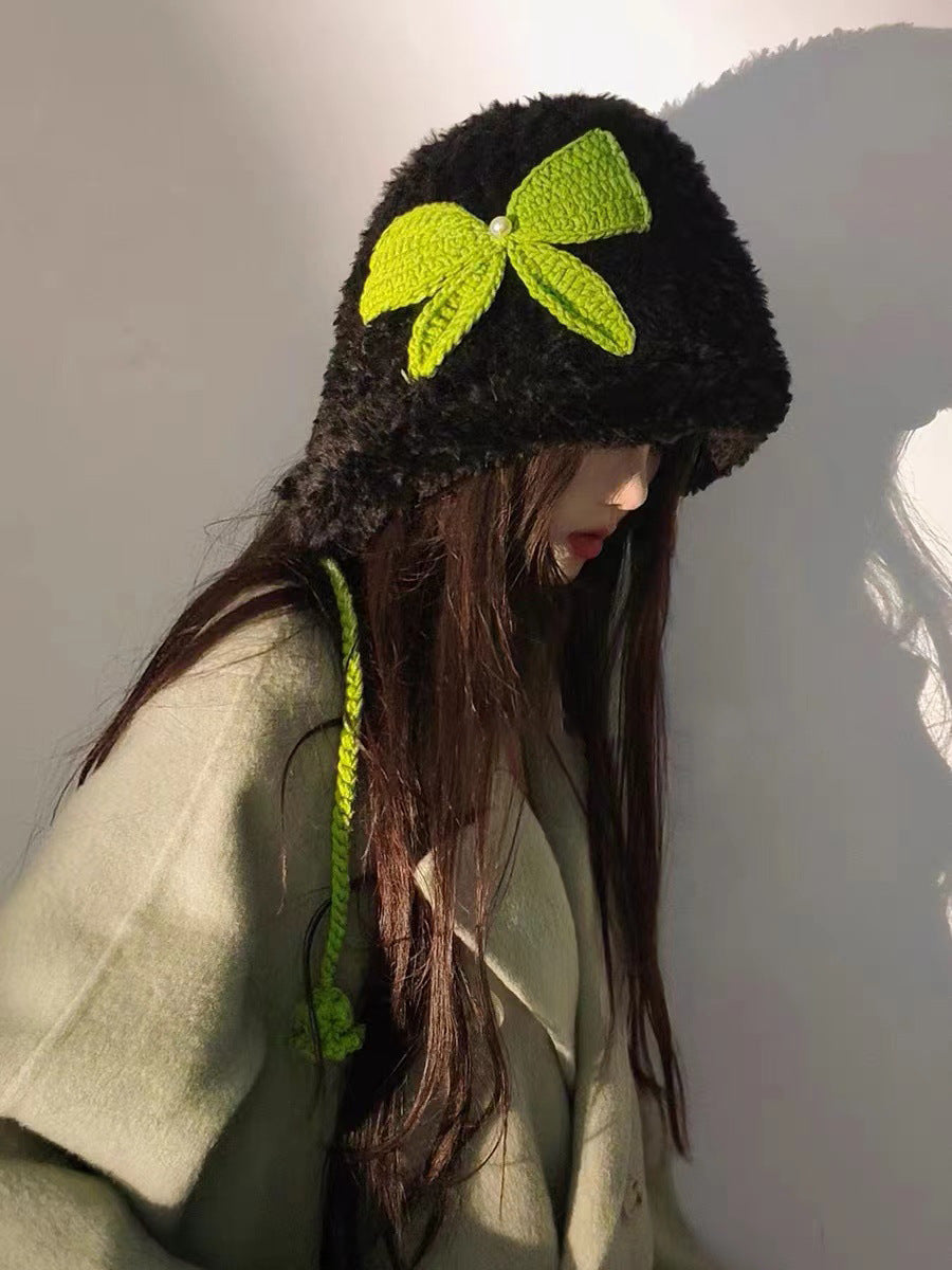 Black fuzzy winter hat adorned with neon green crochet bow and coordinating braided ties
