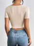 Back view of a beige ribbed crop top with short sleeves.