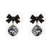 Product photo of black bow earrings with cushion-cut gray crystals against white background