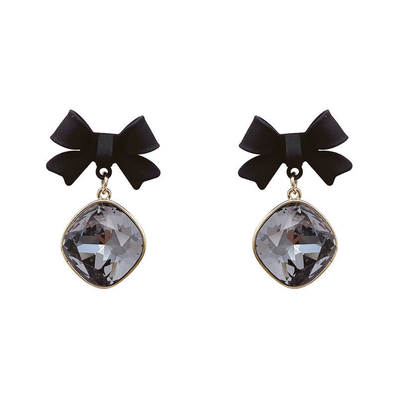 Product photo of black bow earrings with cushion-cut gray crystals against white background