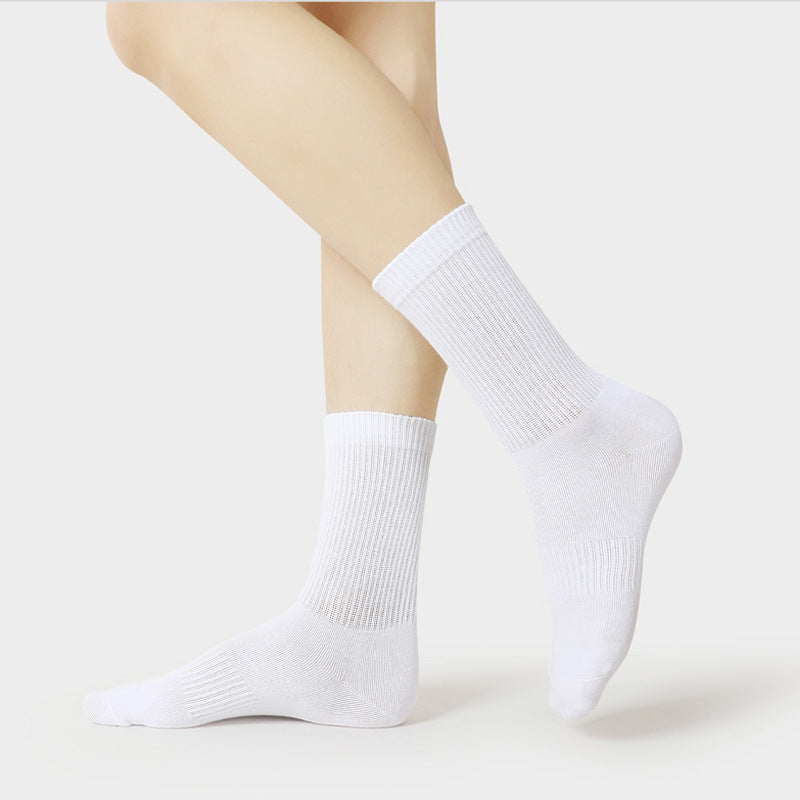 Side view of model's ankles wearing white ribbed crew sports socks with detailed texture visible against white background