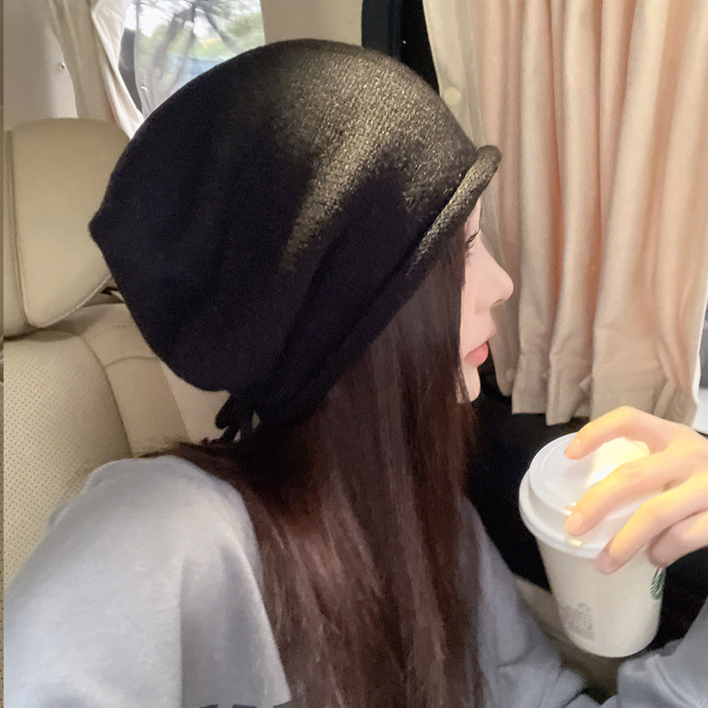 Side profile of black beanie and gray sweater with Starbucks cup