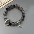 Crystal bracelet with gold flecks, featuring silver moon charm and leaf detail