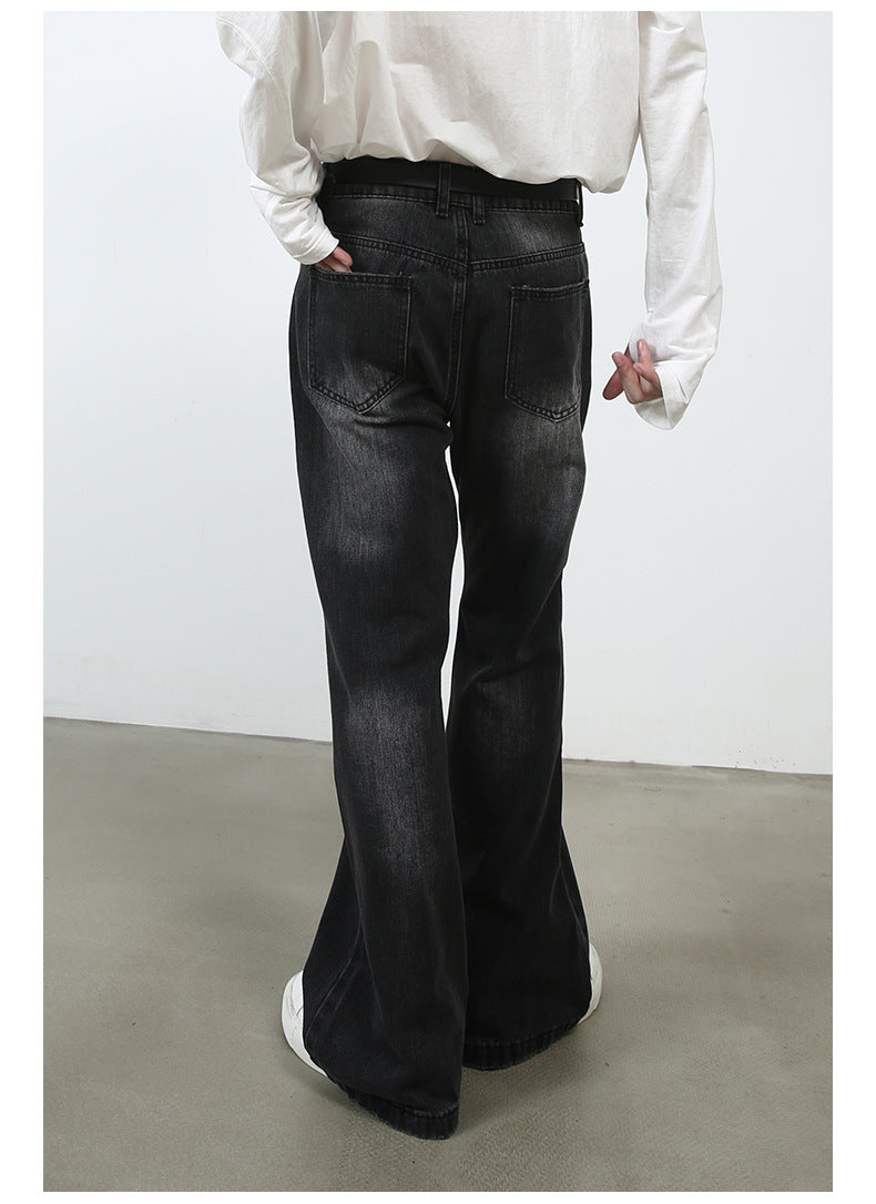 Rear three-quarter view of model with hand in pocket wearing white shirt and black wide-leg jeans against white background