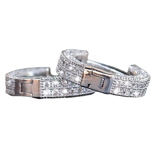 Two silver tone crystal-encrusted hinged hoop earrings with clasp closure, displayed on white background showing detailed pave setting