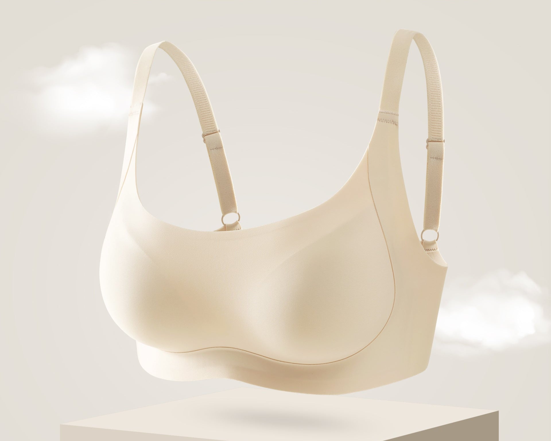 Seamless nude-colored bra with soft support and adjustable straps, floating on a neutral background.