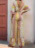 Back view of a woman in a V-back patchwork jumpsuit with a tie detail, loose wide-leg pants, and bohemian-inspired print.