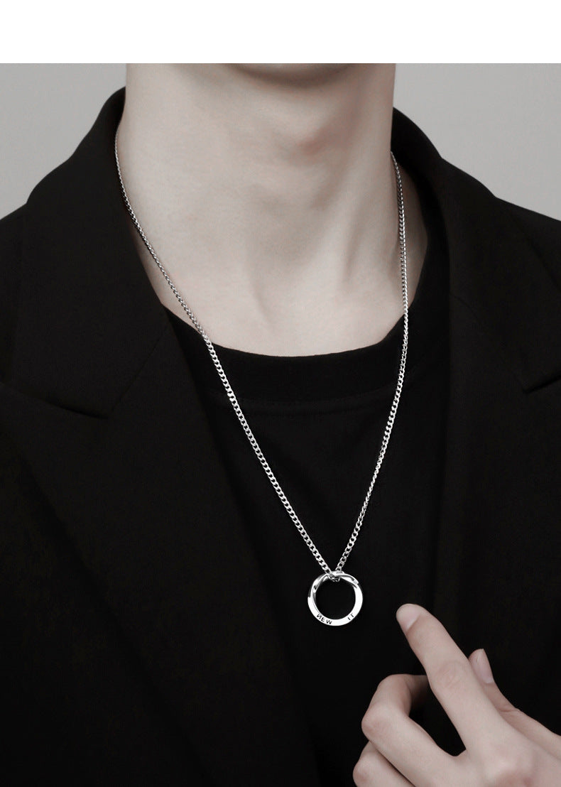 Silver chain necklace with circular pendant worn with black outfit