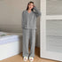 Standing pose in gray loungewear set with white hair clips and smiley face slippers