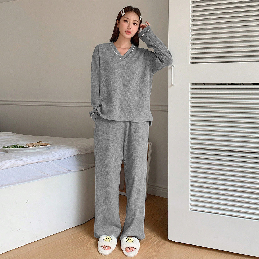 Standing pose in gray loungewear set with white hair clips and smiley face slippers