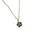 Close-up of gold chain necklace with black rose pendant featuring crystal-lined petals
