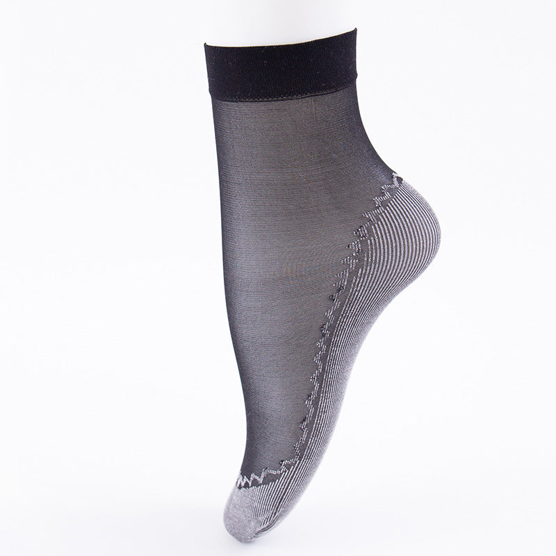 Product photo of black sheer ankle sock with ribbed sole detail against white background