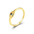 Angled view of gold ring with blue sapphire in stylized eye design on white background