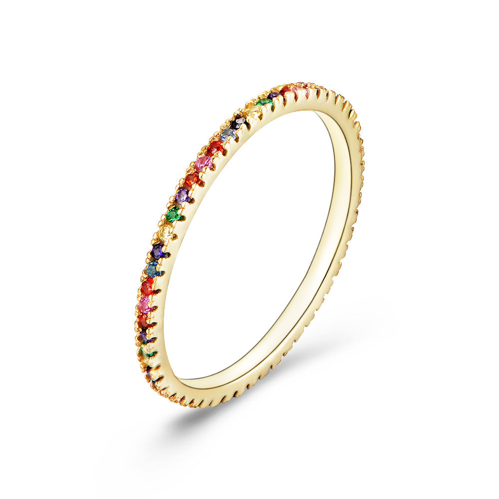 Rainbow gemstone eternity ring with emerald, sapphire, ruby and zircon in gold setting, angled view