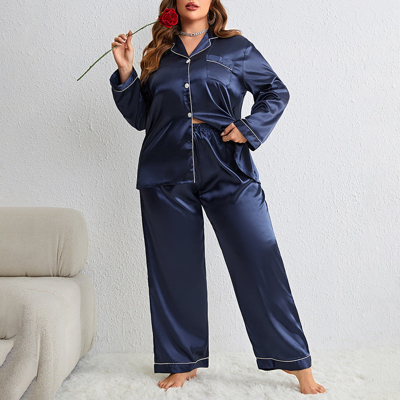 Model in navy silk pajama set holding red rose, showing button-front top and wide-leg pants on white carpet
