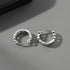 Two sterling silver chain-pattern hoops displayed on light gray surface.