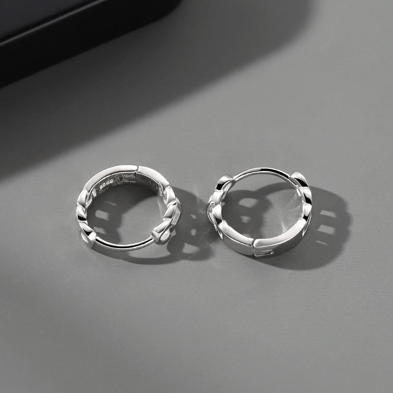 Two sterling silver chain-pattern hoops displayed on light gray surface.