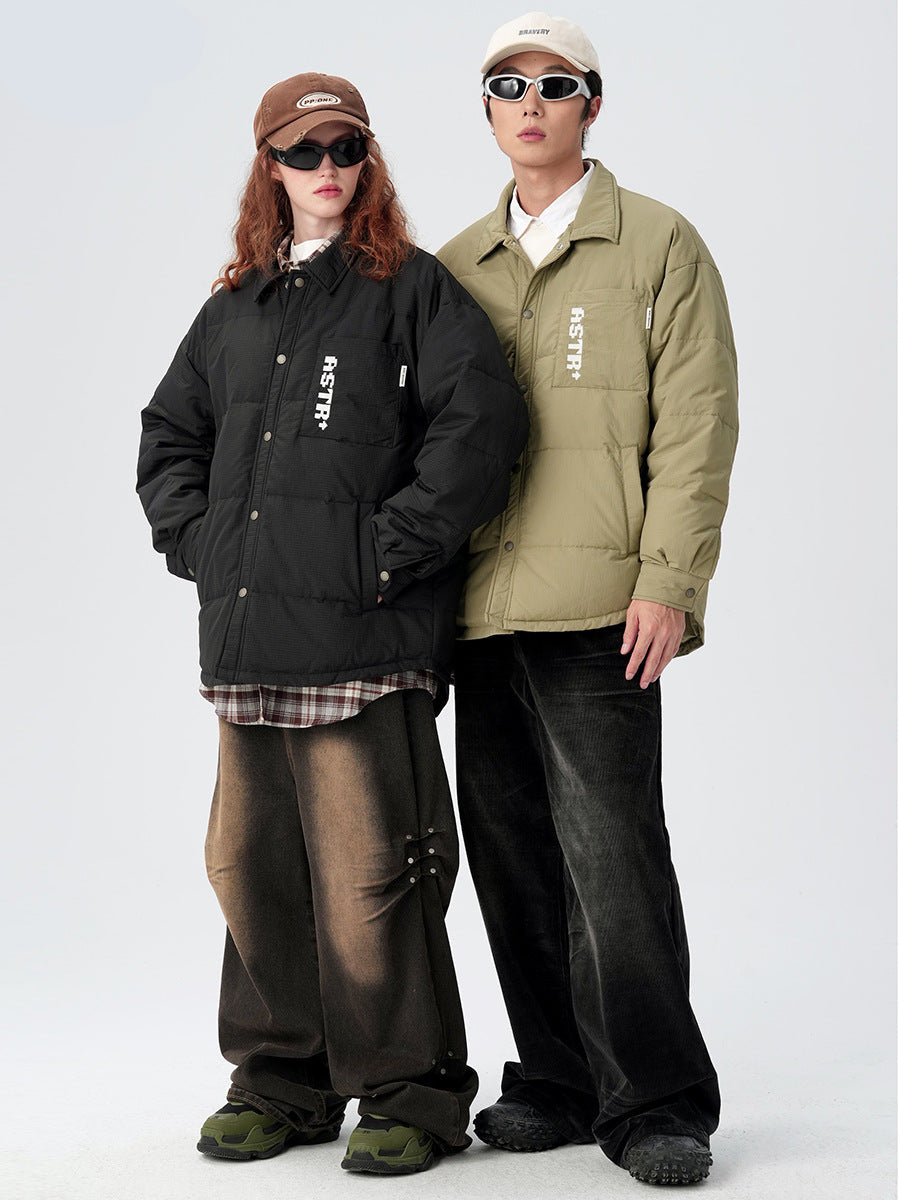 Models standing side by side in ASTROSMASH puffer jackets - black and olive versions with white logos and sunglasses