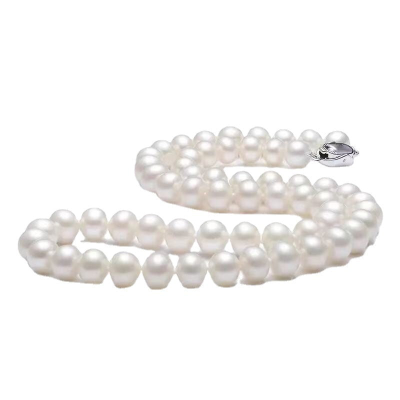 White pearl necklace laid in S-shape with silver clasp, displaying uniform round pearls