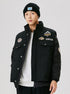 Front view of black outdoor jacket with camping and brave game patches, worn with white t-shirt and black beanie